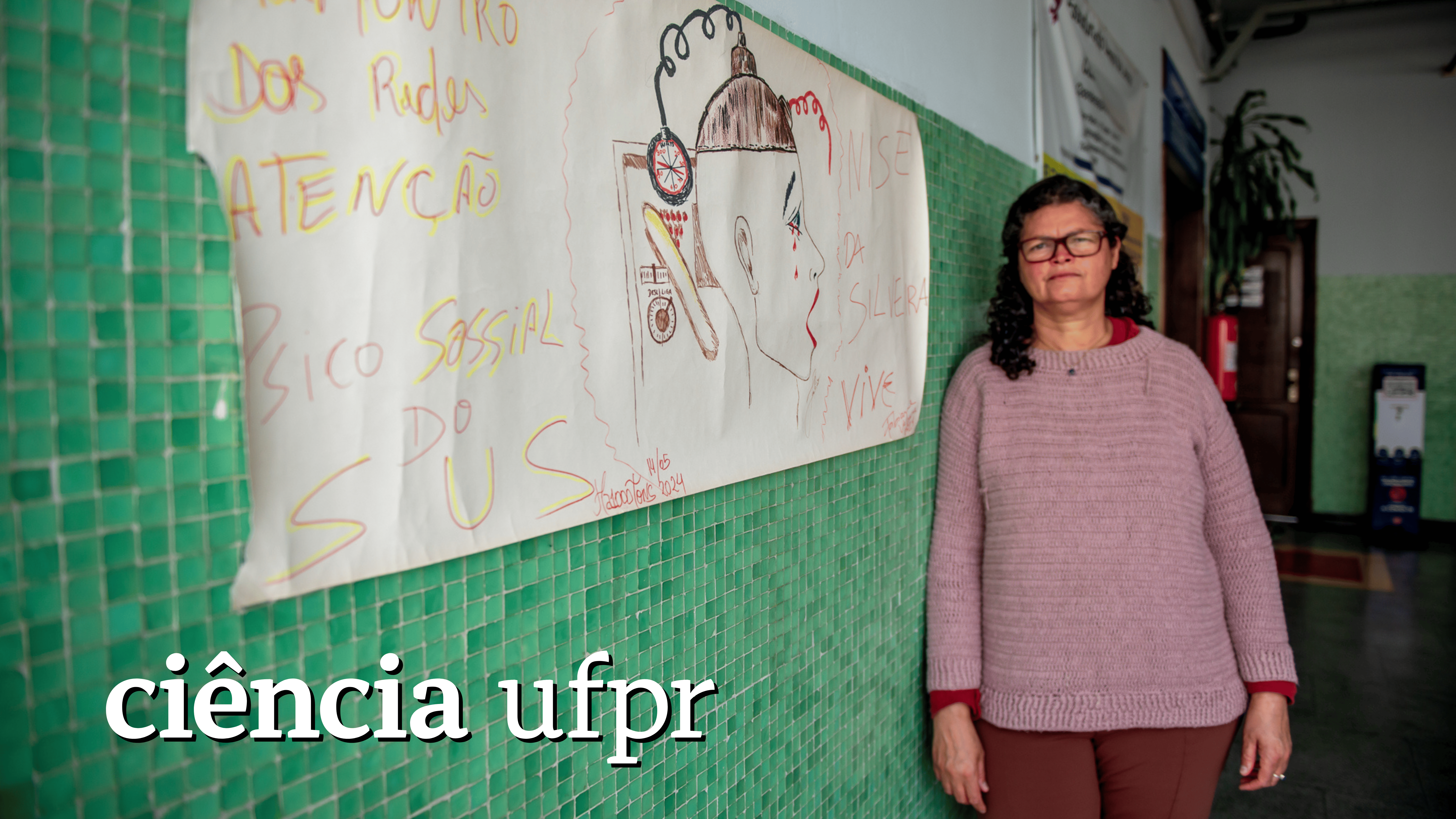 Fabiane Valmore no andar do Departamento de Sociologia da UFPR, em Curitiba, ao lado de desenho do artista de rua Júlio César Ferreira. Foto: Marcos Solivan/Sucom UFPR